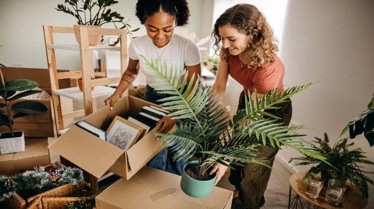 Two women unpacking boxes in a new home