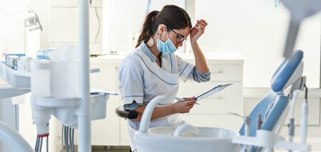 A woman wearing a mask in a dental office